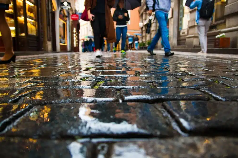 People Walking on Wet Paving Stones in Old Town